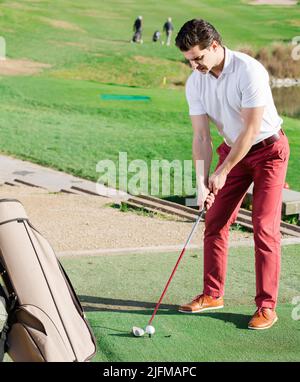 Mann, der Golf spielt, wird auf dem Golfplatz Ball schlagen Stockfoto