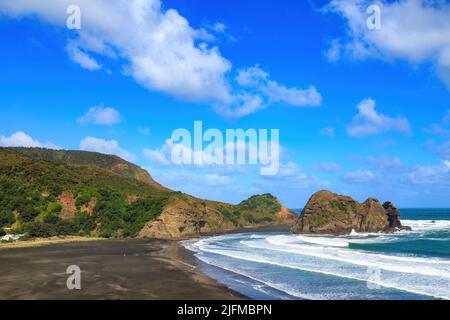 Piha Beach, Neuseeland. Blick am Strand entlang auf die Insel Taitomo und den Nun Rock Stockfoto