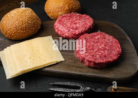 Hacksteaks von Rindfleisch und Schweinefleisch auf schwarzem, dunklem Steintisch Stockfoto