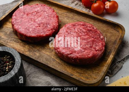Frische rohe Hackfleisch hausgemachte Bauern Grill Rindfleisch Burger auf grauen Stein Tisch Hintergrund Stockfoto