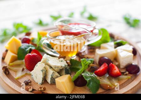 Weinsnacks auf Holzschneidebrett aus der Nähe Stockfoto