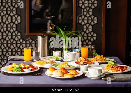 Speisen und Getränke, die für zwei Personen am Tisch serviert werden, zum Frühstück oder zum Brunch am Morgen im Restaurant. Konzept der Wochenend-Urlaub, Rest im Urlaub in Stockfoto