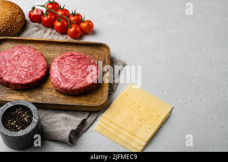 Startseite Handmade Raw Hackfleisch Beef Steak Burger auf grauen Stein Tisch Hintergrund, mit Platz für Text kopieren Stockfoto
