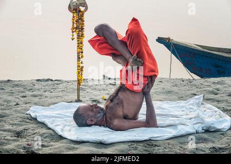 Sadhu praktiziert Yoga bei Sonnenaufgang am Ufer des Ganges, Allahabad Kumbh Mela, der größten religiösen Versammlung der Welt, Uttar Pradesh, Indien Stockfoto