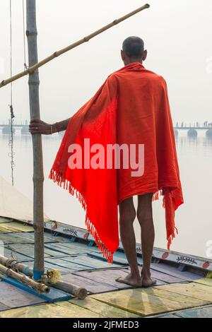 Sadhu mit rotem Schal auf einer Bootsfahrt auf dem Ganges bei Sonnenaufgang, Allahabad Kumbh Mela, der weltweit größte religiöse Versammlung, Uttar Pradesh, Indien Stockfoto