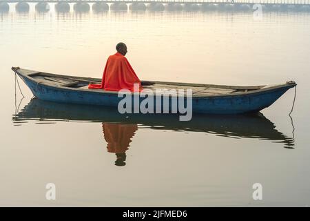 Sadhu mit rotem Schal auf einer Bootsfahrt auf dem Ganges bei Sonnenaufgang, Allahabad Kumbh Mela, der weltweit größte religiöse Versammlung, Uttar Pradesh, Indien Stockfoto