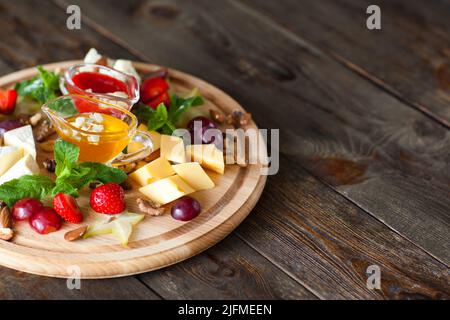 Obst- und Käseplatte auf Holz Freiraum Stockfoto