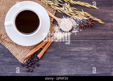 Ähren aus Weizen und eine Tasse Kaffee auf einem dunklen Holztisch Stockfoto