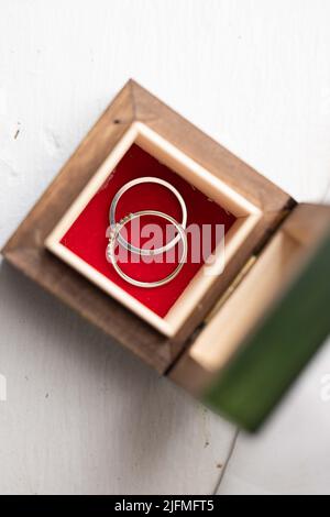 Eine Spitzenaufnahme der Eheringe in einer Vintage-Holzkiste Stockfoto