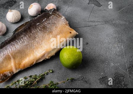 Ganze geräucherte Forellenfische, auf grauem Steintisch-Hintergrund, mit Platz für Text Stockfoto