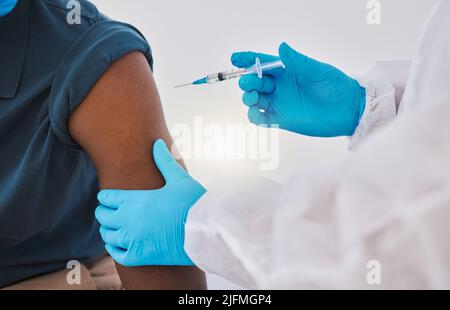 Hände eines Arztes, der bereit ist, einen Patienten mit dem kovidierten Impfstoff zu injizieren. Medizinisches Fachpersonal, das einen Patienten mit Corona-Virus-Heilung injiziert, wurde abgeschnitten Stockfoto
