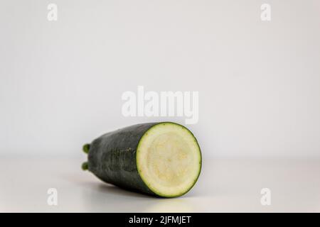 Zucchini in Scheiben vor weißem Hintergrund Stockfoto