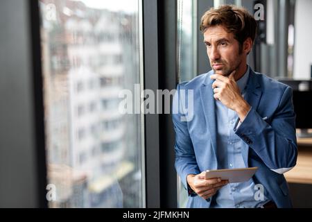 Porträt eines frustrierten gestressten Geschäftsmanns, der in einem Unternehmensbüro arbeitet Stockfoto