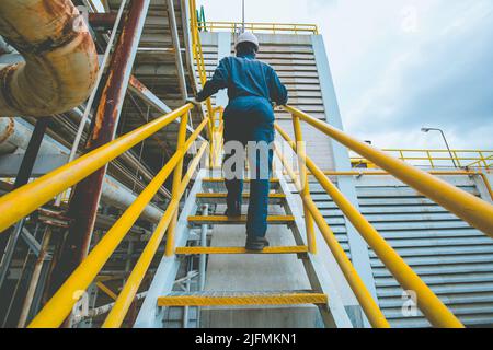 Mann, der die Treppeninspektion in der Fabrik hochgeht Stockfoto