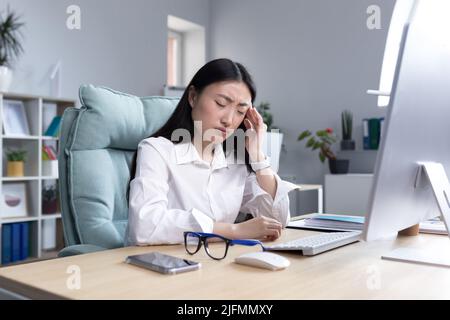 Traurige und müde Geschäftsfrau in Depressionen, enttäuscht vom Arbeitsergebnis, asiatische Frau im Büro. Stockfoto