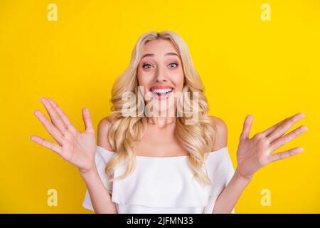 Portrait von attraktiven erstaunt fröhlich wellig-haarige Mädchen mit Spaß gute Nachrichten isoliert über hellen gelben Hintergrund Stockfoto