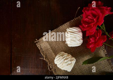 Natürliche handgefertigte Marschmeichs auf Sacking. Rustikaler Hintergrund mit frischen rustikalen Rosen. Draufsicht. Speicherplatz kopieren. Stockfoto