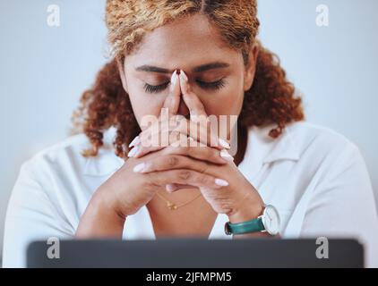 Nahaufnahme einer Geschäftsfrau mit gemischter Rasse, die an Kopfschmerzen leidet, die allein am Laptop bei der Arbeit arbeitet. Hispanische Frau betonte während der Arbeit. Weibliche Chefin Stockfoto