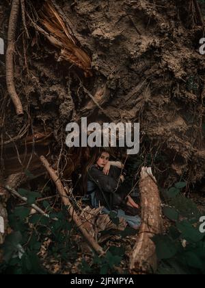 Eine geheimnisvolle Hexe geht in einem dunklen Wald Stockfoto