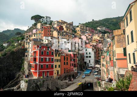 Riomaggiore, Italien - Juni 11. 2021: Schöne Aussicht auf Riomaggiore, beliebtes und berühmtes Touristenziel in 5 Terre. Bunte Häuser am Mittelmeer Stockfoto