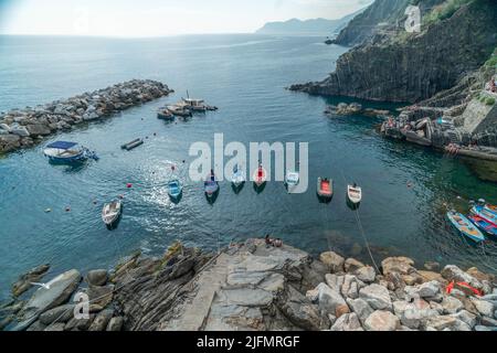 Riomaggiore, Italien - Juni 11. 2021: Kleine Fischerboote in Riomaggiore, 5 Terre. Hochwinkelansicht der Boote im Mittelmeer Stockfoto