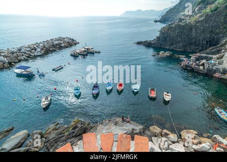 Riomaggiore, Italien - Juni 11. 2021: Kleine Fischerboote in Riomaggiore, 5 Terre. Hochwinkelansicht der Boote im Mittelmeer Stockfoto