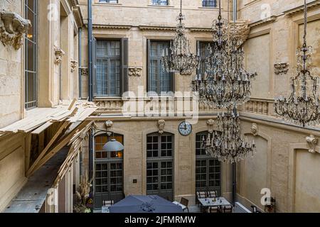 Im Innenhof des Hôtel Richer de Belleval in Montpellier, Frankreich, stellte der japanische Künstler Tadashi Kawamata 2022 seine Installation „Nid“ (Vogelnester) aus Holzlatten aus. Die historische Fassade mit ihren Arkaden und Balkonen rahmt das zeitgenössische Kunstwerk ein. Stockfoto