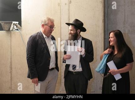 Potsdam, Deutschland. 04.. Juli 2022. Architekt Jost Haberland (l-r), Potsdamer Rabbiner David Gewirtz und die Brandenburgische Ministerin für Wissenschaft, Forschung und Kultur, Manja Schüle (SPD) sprechen bei einem Rundgang durch die Synagogenbaustelle im Untergeschoss hinter dem Mikveh-Becken (Jüdisches Tauchbad). Neben Gebetsräumen wird das neue Zentrum auch einen Veranstaltungsraum und das Besuchercafé sowie Gemeinschafts- und Büroräume beherbergen. Quelle: Soeren Stache/dpa/Alamy Live News Stockfoto