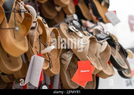 Batumi, Georgia - 31 2022. Mai: Nahaufnahme von Damensommerschuhen, die im Laden an der Wand hängen Stockfoto