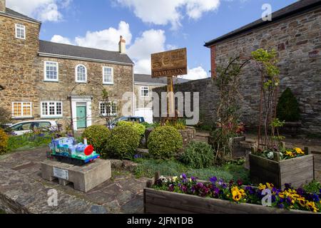 BAMPTON, DEVON, Großbritannien - 7. APRIL 2022 Bampton Stadtschild und Gärten auf der Fore Street Stockfoto