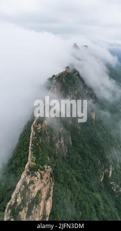 Peking, China. 4.. Juli 2022. Luftaufnahme vom 4. Juli 2022 zeigt Wolken, die über der Großen Mauer im Grenzgebiet zwischen dem Luanping Bezirk in der nordchinesischen Provinz Hebei und dem Miyun Bezirk in Peking, der Hauptstadt Chinas, schweben. Quelle: Chen Yehua/Xinhua/Alamy Live News Stockfoto