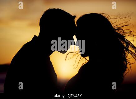 Silhouette Paar genießen romantischen Moment mit ihren Stirnen berühren vor Sonnenuntergang Hintergrund. Unbekannter Freund und Freundin sich verliebt Stockfoto