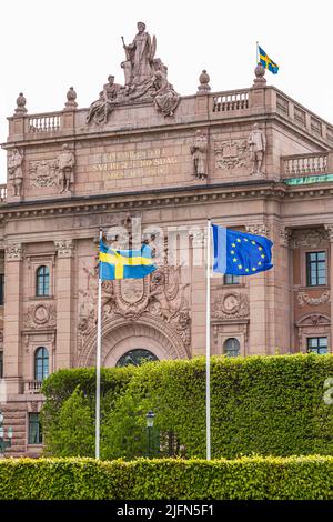 Die schwedische Nationalflagge und die Flagge der Europäischen Union, die vor dem Parlamentsgebäude (Riksdag) in Stockholm, Schweden, fliegt Stockfoto