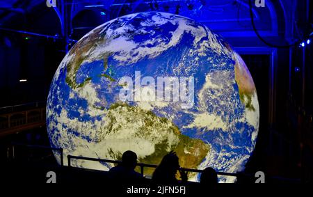 Hartlepool, Großbritannien. 04. Juli 2022. Im Town Hall Theatre, Hartlepool, Großbritannien, wird eine atemberaubende, beleuchtete Nachbildung des Planeten Erde mit dem Namen ‘Gaia’ von Luke Jerram gezeigt. Mitglieder der Öffentlichkeit wurden eingeladen, die enorme Kunstattraktion von Weltrang mit einem Durchmesser von 7 Metern zu sehen, die im Rahmen ihrer kulturellen Aktivitäten vom Hartlepool Council in die Region gebracht wurde. Kinder und Erwachsene wurden in Ehrfurcht gelassen. Quelle: Teesside Snapper/Alamy Live News Stockfoto