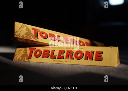 Eine Toblerone-Schokolade in der Abendsonne auf einem Küchentisch zu Hause. Toblerone wird das Etikett „der Schweiz“ von der Vorderseite seiner Verpackung verlieren, nachdem er sich für die Eröffnung eines Produktionsstandorts für Schokolade in der Slowakei entschieden hat. Stockfoto