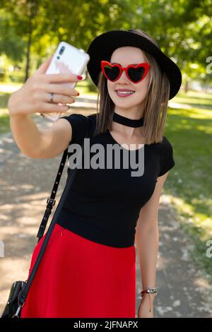 Portrait der schönen Frau macht Selfie im Park. Stockfoto