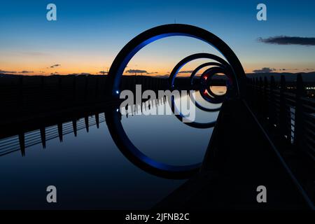 Falkirk, Großbritannien - 19. Juni 2022: Blick auf das Falkirk Wheel bei Sonnenuntergang mit Lichtern in verschiedenen leuchtenden Farben Stockfoto