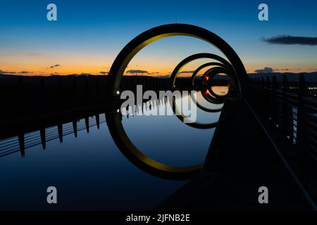 Falkirk, Großbritannien - 19. Juni 2022: Blick auf das Falkirk Wheel bei Sonnenuntergang mit Lichtern in verschiedenen leuchtenden Farben Stockfoto