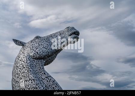 Falkirk, Vereinigtes Königreich - 20. Juni 2022: Eine der Kelpies-Pferdekopfskulpturen mit einem ausdrucksstarken, langbelichteten Himmel dahinter Stockfoto