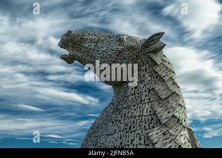 Falkirk, Vereinigtes Königreich - 20. Juni 2022: Eine der Kelpies-Pferdekopfskulpturen mit einem ausdrucksstarken, langbelichteten Himmel dahinter Stockfoto