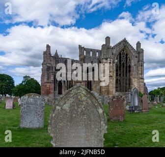 Melrose, Vereinigtes Königreich - 19. Juni 2022: Blick auf die Ruinen der Melrose Abbey und historische Grabsteine auf dem Kirchhof Stockfoto