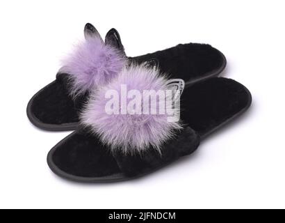 Weiche, flauschige schwarze Pantoffeln mit Pompoms und Ohren auf Weiß isoliert Stockfoto