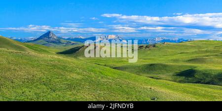 Panorama der Präriehügel unterhalb der felsigen Bergfront in der Nähe von augusta, montana Stockfoto