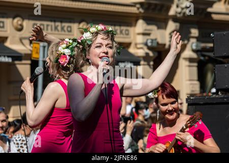 Zwei Sängerinnen und eine Ukulelespielerin bei der Helsinki Samba Carnaval Parade in Pohjoisesplanadi, Helsinki, Finnland Stockfoto