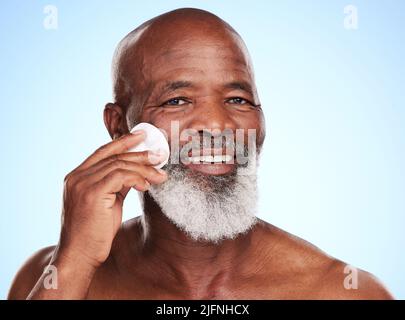 Peeling ist der Schlüssel. Beschnittenes Porträt eines hübschen reifen Mannes, der im Studio vor blauem Hintergrund posiert. Stockfoto