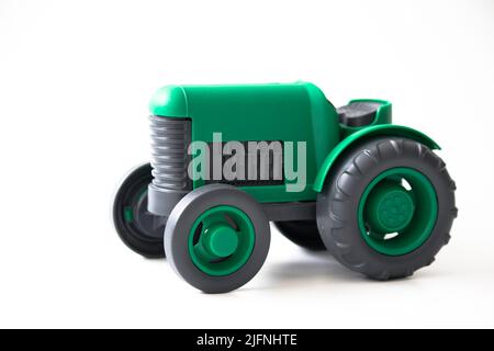 Traktor. Spielzeug für Kinder. Grüner Spielzeugtraktor isoliert auf weißem Hintergrund. Speicherplatz kopieren. Platz für Text. Keine Menschen, niemand. Stockfoto