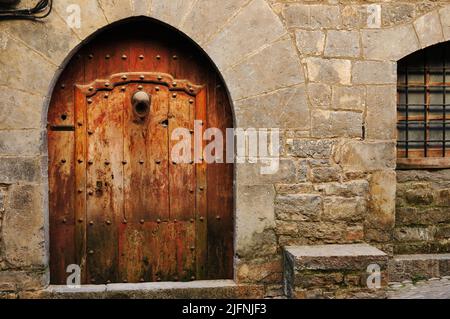 Alte gewölbte Holztür. Traditionelle Architektur. Aínsa ist die Hauptstadt der Gemeinde Aínsa-Sobrarbe. Aínsa, Aínsa-Sobrarbe, Huesca, Aragón, Stockfoto