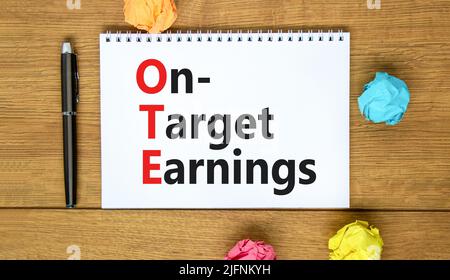 OTE-Symbol für die angestrebten Gewinne. Das Konzept formuliert die Zielgewinne des OTE auf einer weißen Note auf einem schönen Holzhintergrund. Metallstift. Geschäfts- und OTE-on- Stockfoto