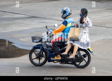 SAMUT PRAKAN, THAILAND, 28 2022. MÄRZ, Ein Taxifahrer auf einem Motorrad fährt mit einer Frau. Stockfoto