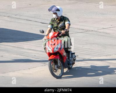 SAMUT PRAKAN, THAILAND, 28 2022. MÄRZ, Ein Mann trägt Tarnuniform fährt ein Motorrad auf der Straße Stockfoto